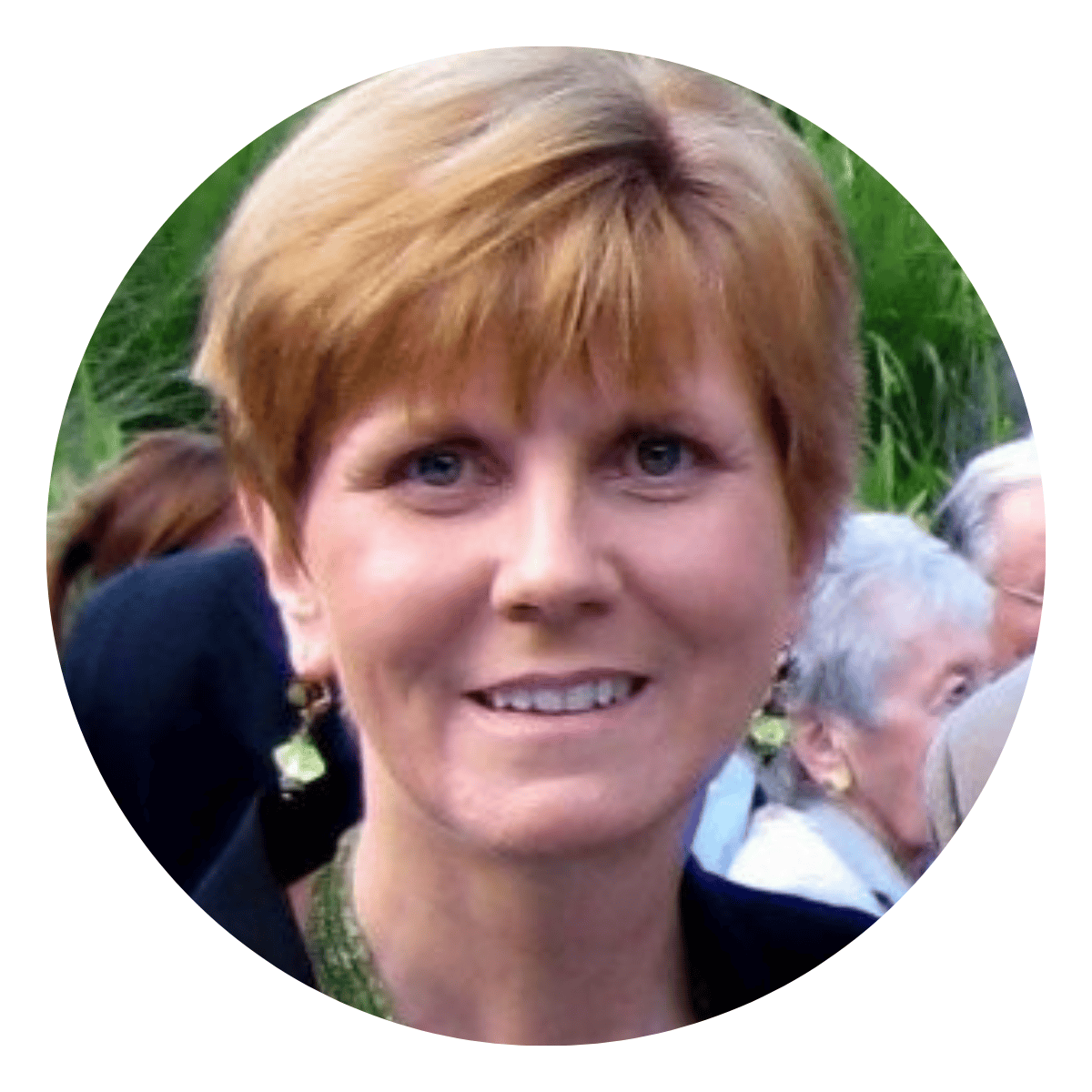 Headshot of a white female mid-50s executive coaching client with short red hair ourside