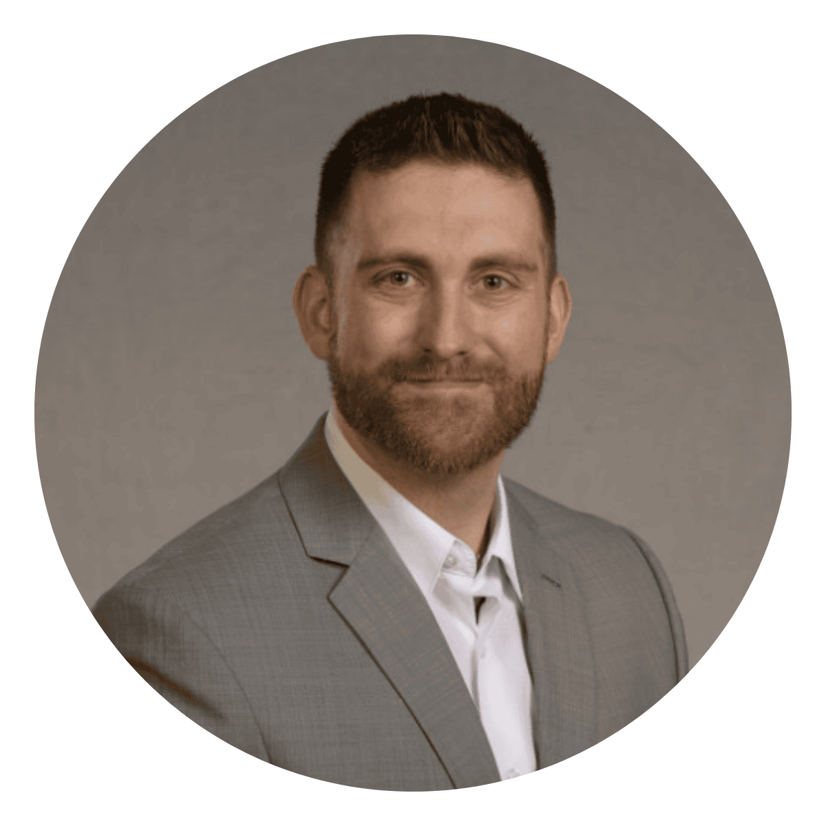 Professional headshot of white male mid-30s executive coaching client in a grey suit